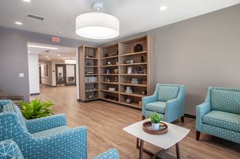 a waiting room at a hospital with blue chairs and a table